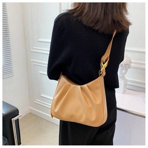 Detailed view of khaki ruched bucket bag with decorative gold chunky chain strap