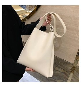 Close-up of minimalist cream white tote bag with wide strap on marble background