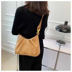 Detail of camel leather pleated hobo bag with thick gold chain link and metal buckle