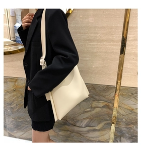 Detail of adjustable shoulder strap and smooth PU leather on cream white tote bag