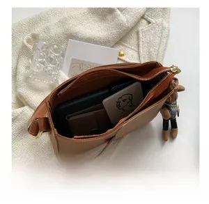 Vue détaillée de l'intérieur du sac en cuir marron avec espace pour téléphone et portefeuille