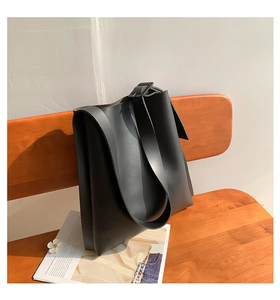 Detail of adjustable wide shoulder strap with square buckle on black tote bag