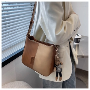 Détail du sac à bandoulière bicolore avec un pendentif lapin et sangle réglable