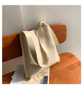 Detail of cream white tote bag with adjustable wide strap and matte leather texture