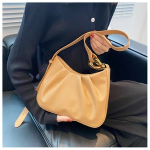 Close-up of camel pleated cloud bag featuring stylish thick gold chain link detail