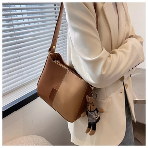 Détail du sac seau bicolore en cuir marron avec une breloque lapin mignonne