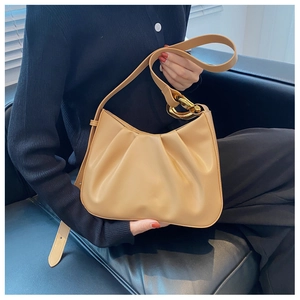 Detail of gathered dumpling bag in beige leather with chunky gold chain strap
