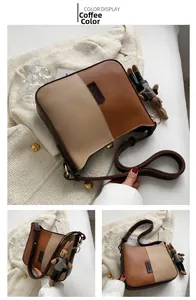 Détail du sac bandoulière bicolore marron et beige avec un joli pendentif lapin