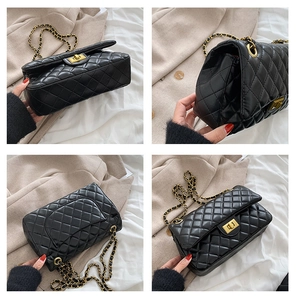 Detail view of black quilted crossbody bag with gold twist lock and chain strap