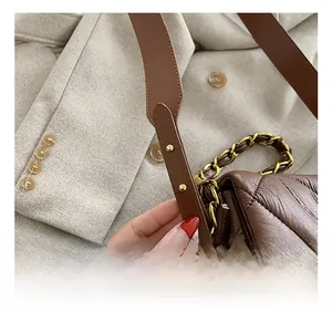 Détail de la bandoulière réglable en cuir sur un sac à bandoulière matelassé marron