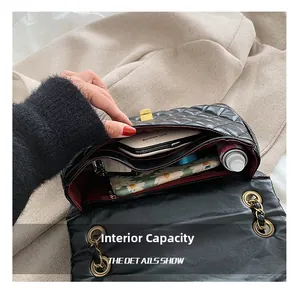 Interior view of black quilted chain bag showing spacious storage for phone and cosmetics