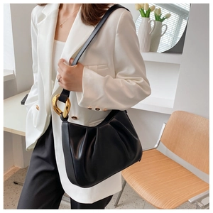 Detail of black pleated cloud bucket bag with premium gold irregular metal buckle detail