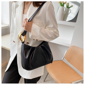 Detail of matte black ruched cloud bag with stylish golden ring buckle on shoulder strap