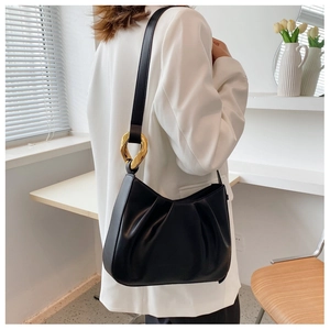 Close-up of black pleated cloud bucket bag with distinctive gold-toned hardware rings