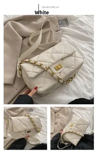 Vue détaillée de la texture cuir matelassé blanc et de la bandoulière chaîne dorée