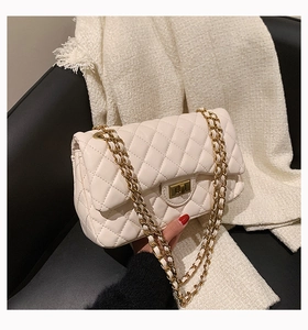 Detail of cream quilted leather bag featuring gold twist lock and chain strap