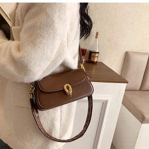 Detail einer dunkelbraunen Vintage-Schultertasche aus Leder mit goldener Metallschnalle