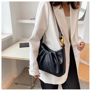 Detail of black pleated cloud bag featuring premium matte PU texture and gold chain link