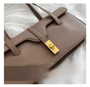 Macro detail of brown litchi pattern leather bag with golden rectangle swivel lock