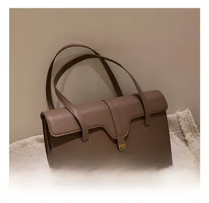 Detail view of mocha brown retro shoulder bag with golden metal twist lock and flap