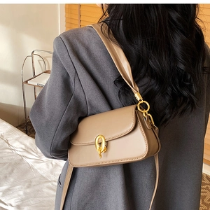 Details einer eleganten beigen Umhängetasche mit stilvoller goldener Ringschnalle am Trageriemen