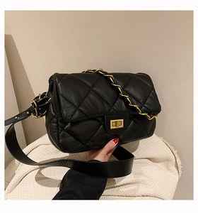 Détail du sac bandoulière en cuir matelassé noir avec fermoir doré et bandoulière chaîne