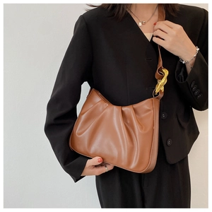 Caramel pleated cloud bag featuring oversized gold metal twist buckles on shoulder strap