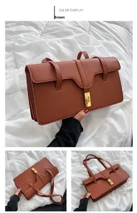 Detail view of brown textured leather shoulder bag with vintage gold metal twist lock