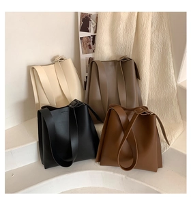 Detail view of large tote bags in cream, taupe, black and brown on white stairs