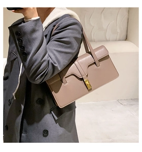 Macro detail of retro underarm bag showing wavy edge flap and golden twist lock