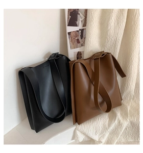 Detail of adjustable wide shoulder straps with buckles on black and brown tote bags
