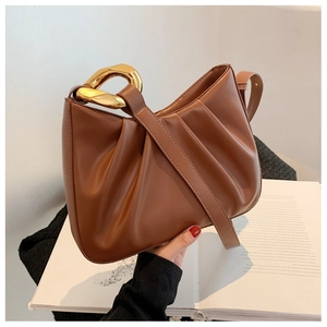 Close-up of brown pleated PU bucket bag featuring a thick gold metallic chain link