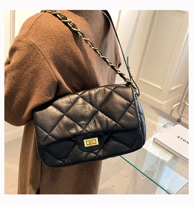 Détail du sac à bandoulière matelassé noir en cuir brillant avec chaîne dorée chic