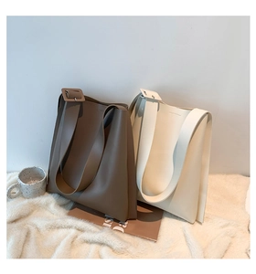 Detail of minimalist tote bags with wide shoulder straps in khaki and off-white colors