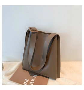 Minimalist coffee brown tote bag with wide shoulder strap shown in a modern home setting