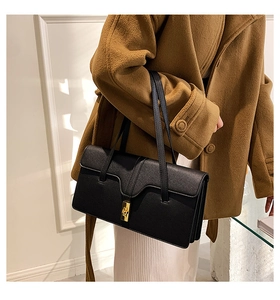 Detail of a black leather shoulder bag featuring a gold square twist lock and fine texture