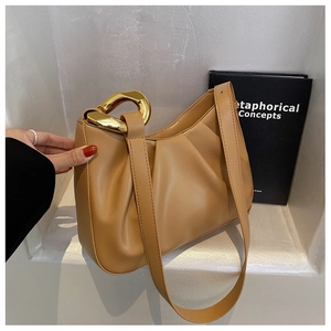 Detail of camel leather pleated cloud bucket bag with chunky gold chain and shoulder strap