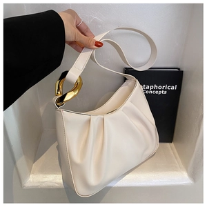 Detail of cream pleated cloud bag featuring bold gold metal rings and soft PU leather