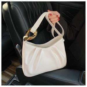 Detail of white pleated cloud bag with a large gold metal twist ring and zipper closure
