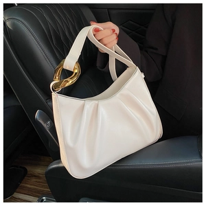 Detail view of the soft pleated cloud bag texture and chunky gold chain link handle