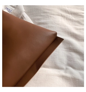 Detailed view of the brown leather shoulder bag's fine texture and neat edge stitching