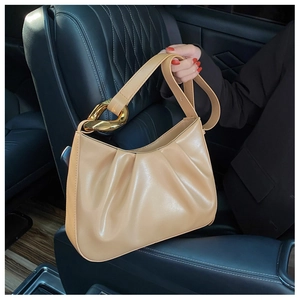 Detail of pleated beige bucket bag with a large gold metal buckle on the shoulder strap