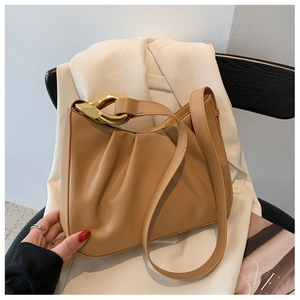 Detail of pleated cloud bucket bag with bold gold chain and soft leather texture