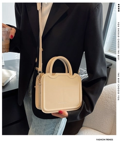 Close-up of beige square crossbody bag with Fashion & Bags engraving and handle detail