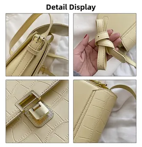 Detail of yellow crocodile pattern handbag showing metal lock and knotted strap