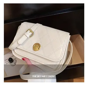 Detail showing beige quilted crossbody bag with golden rotary lock and adjustable strap