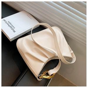 Close-up of white cloud bucket bag with soft pleated texture and gold metal buckle