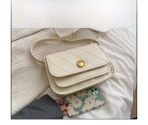 Quilted crossbody bag next to a smartphone showing size comparison on white fabric