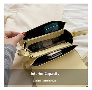 Internal capacity detail of beige shoulder bag showing multiple compartments and zipper