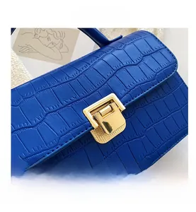 Dettaglio borsa blu reale con trama a coccodrillo e fibbia in metallo dorato fine